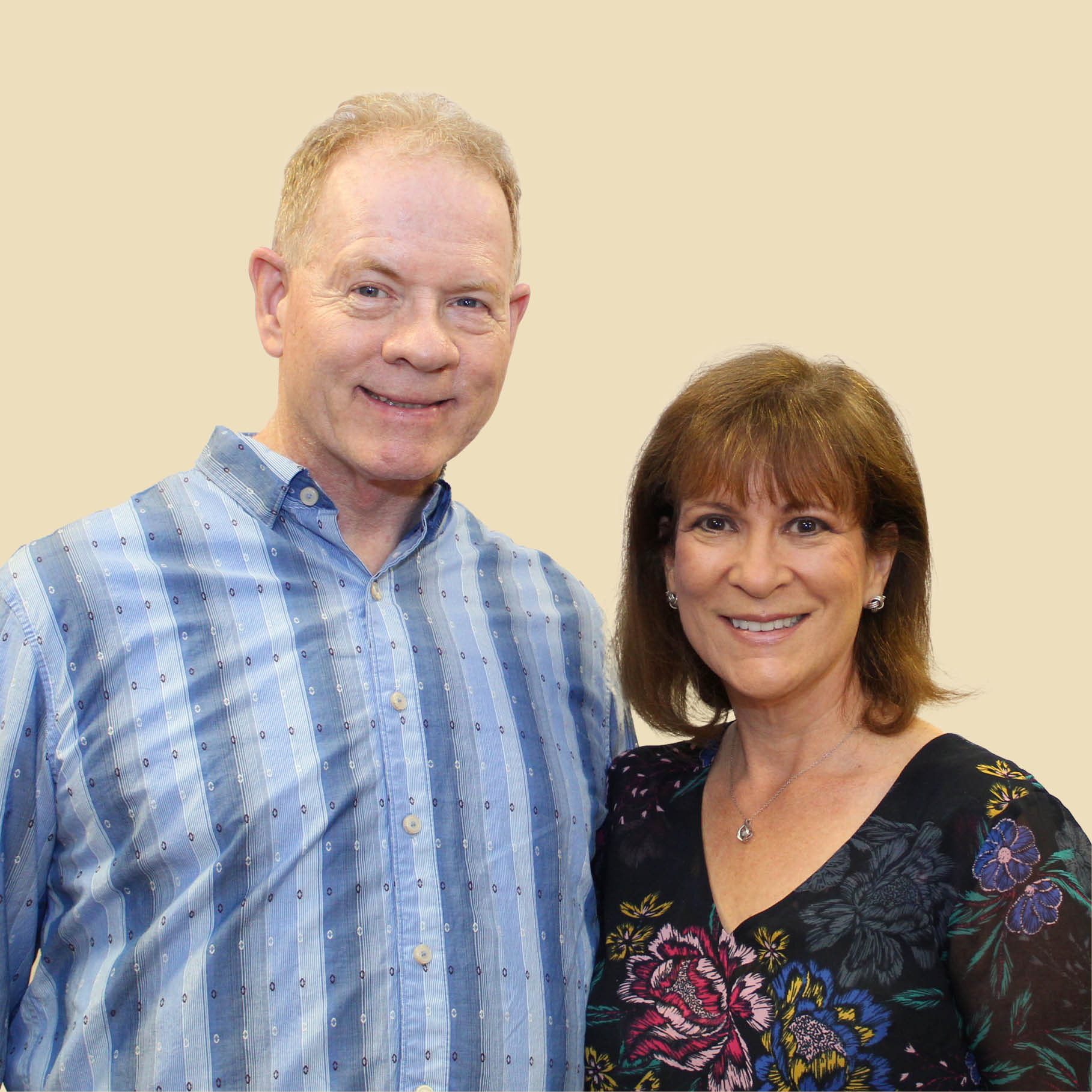 Smiling customers in front of a beige background.