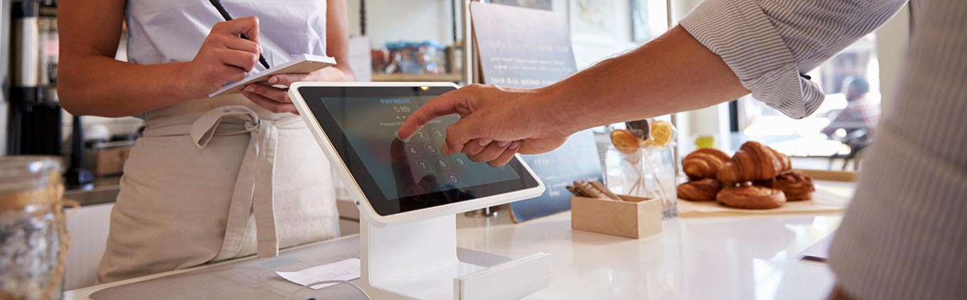 Shop owner using cash register.