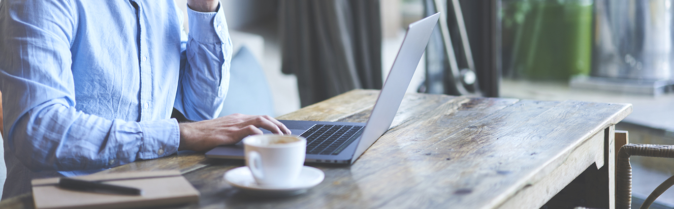 Man using laptop in cafe