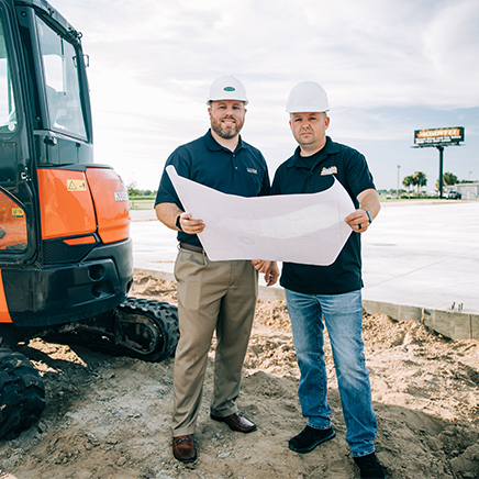 Customer and CFB lender holding plans on a construction site.